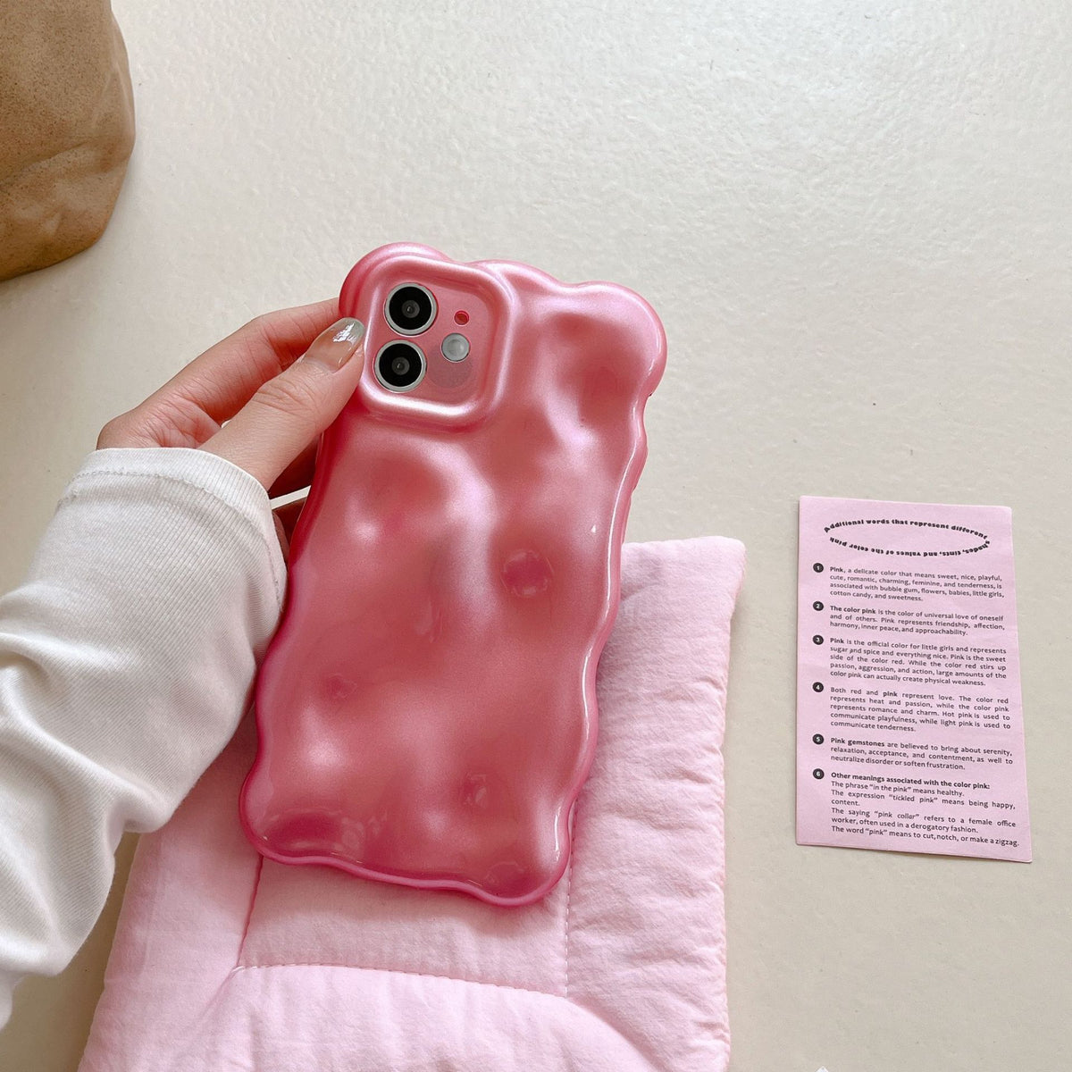 a hand holding a pink phone case