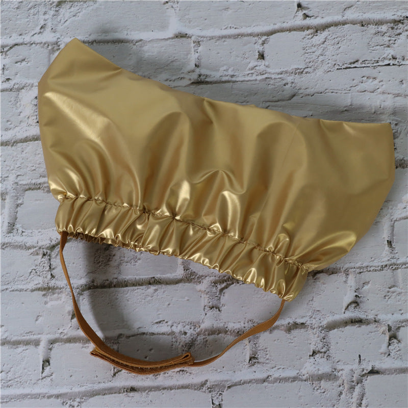 a gold shiny hat on a white brick wall