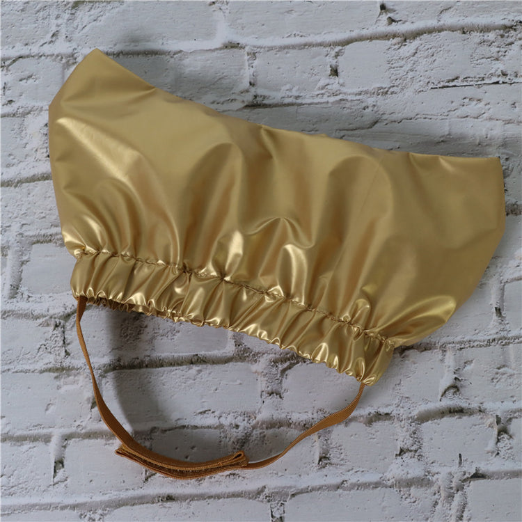 a gold shiny hat on a white brick wall