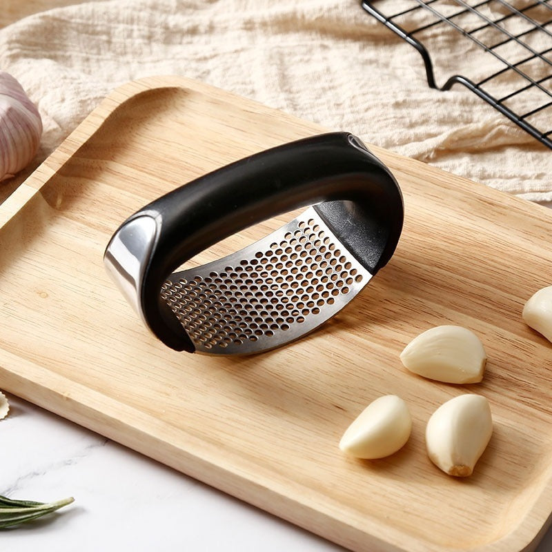 a garlic cloves and a grater on a wooden cutting board