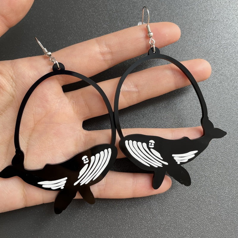 a hand holding a pair of earrings
