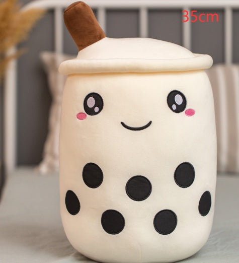 a white and black plushie with a face and black dots