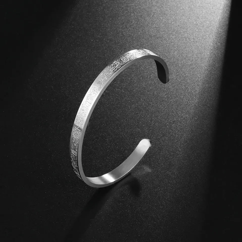 a silver bracelet on a black surface