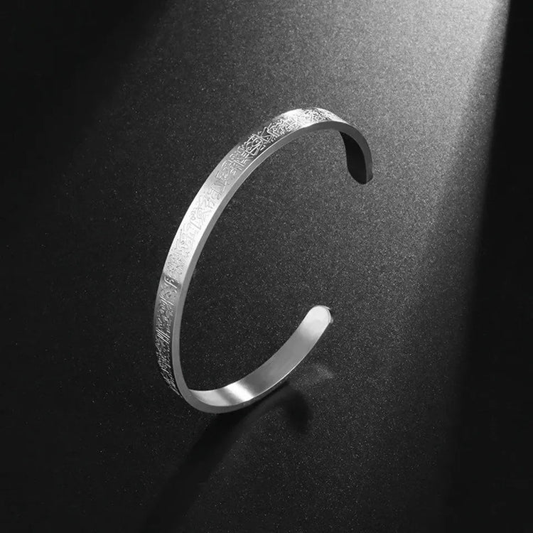 a silver bracelet on a black surface