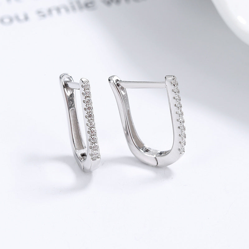 a pair of earrings with diamonds