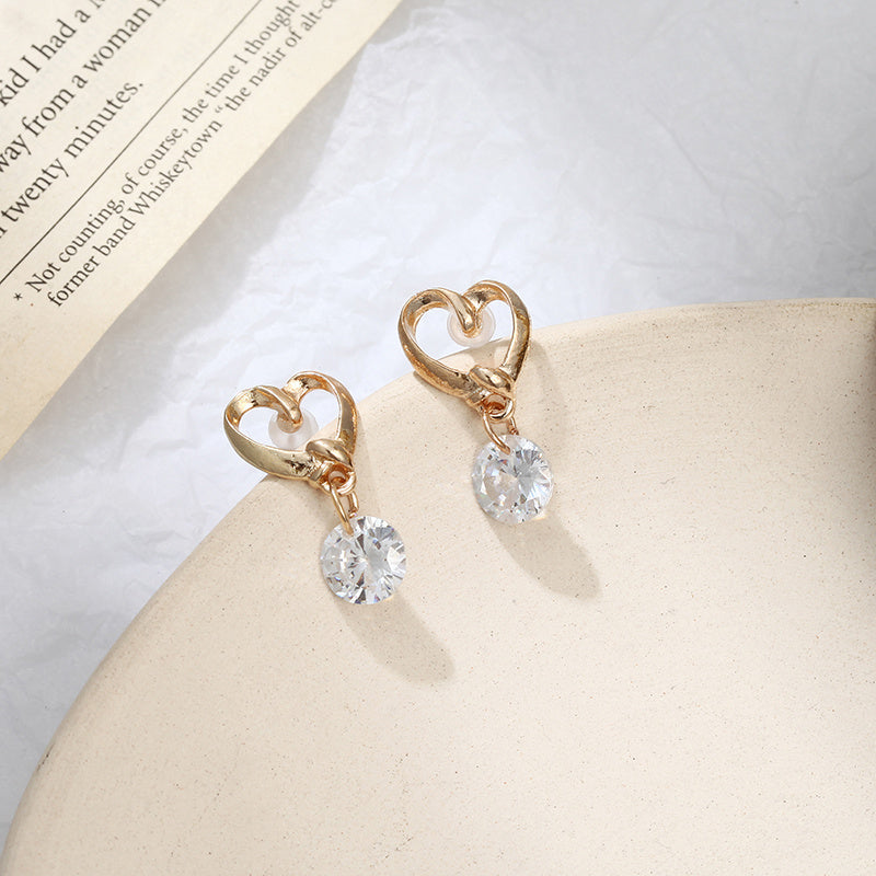 a pair of gold heart shaped earrings