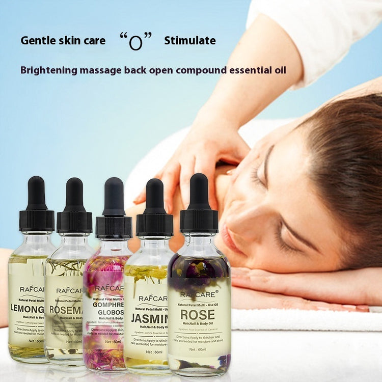 a woman lying down on a towel with bottles of essential oil
