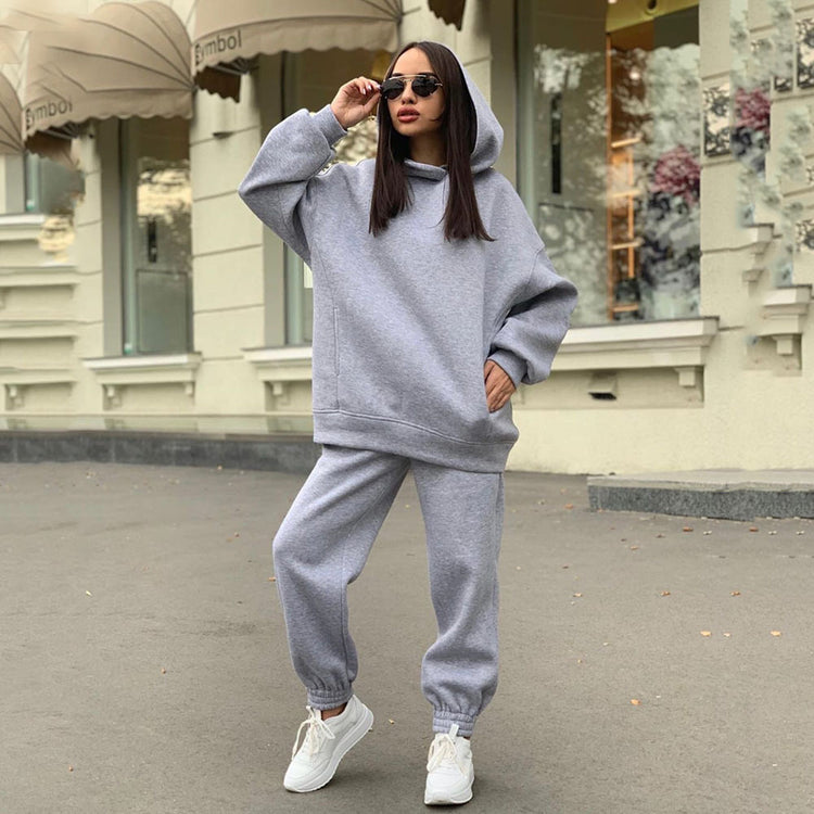a woman wearing a grey hoodie and sunglasses