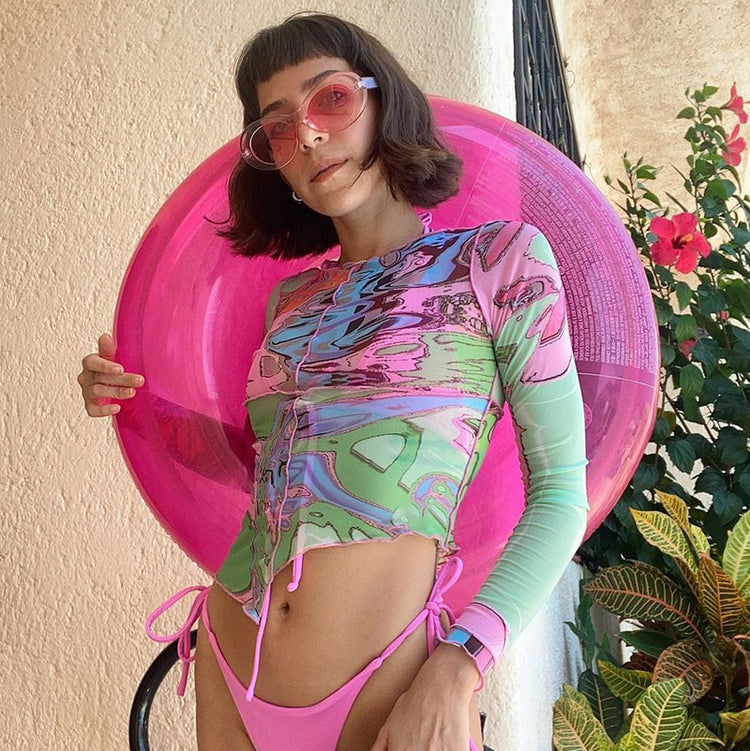 a woman wearing a swimsuit and holding a pink float