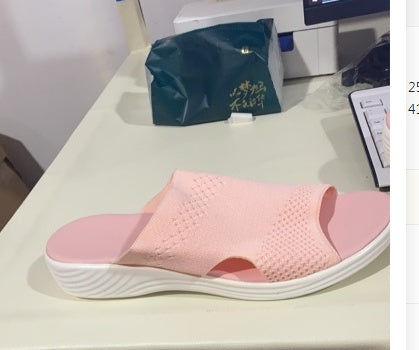 a pink slipper on a white surface