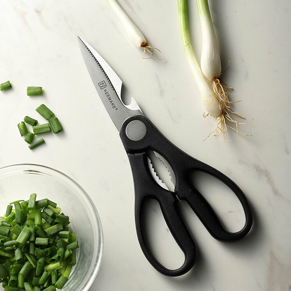 a pair of scissors next to a bowl of green onions