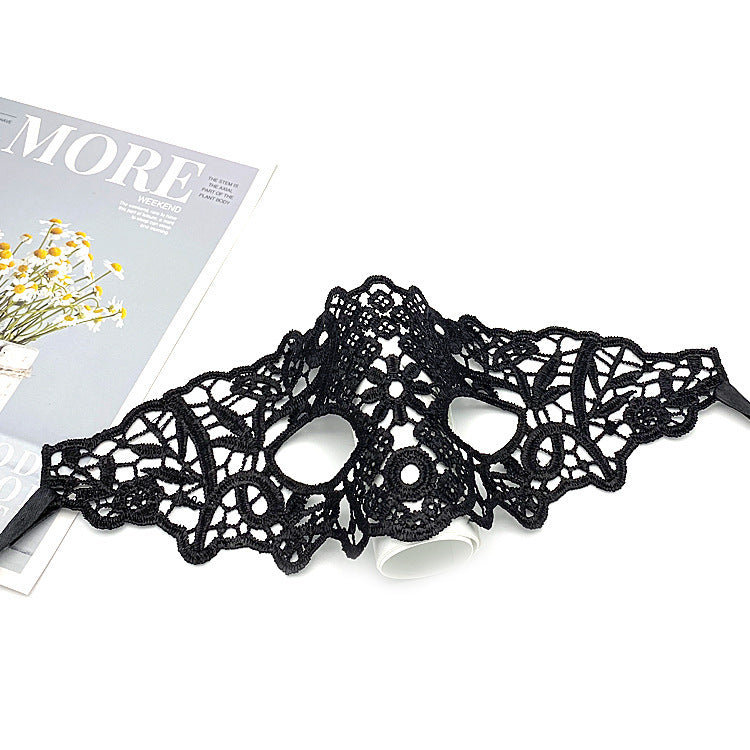a black lace mask on a white surface