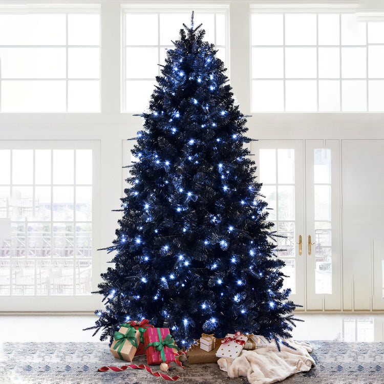 a christmas tree with presents in front of a window