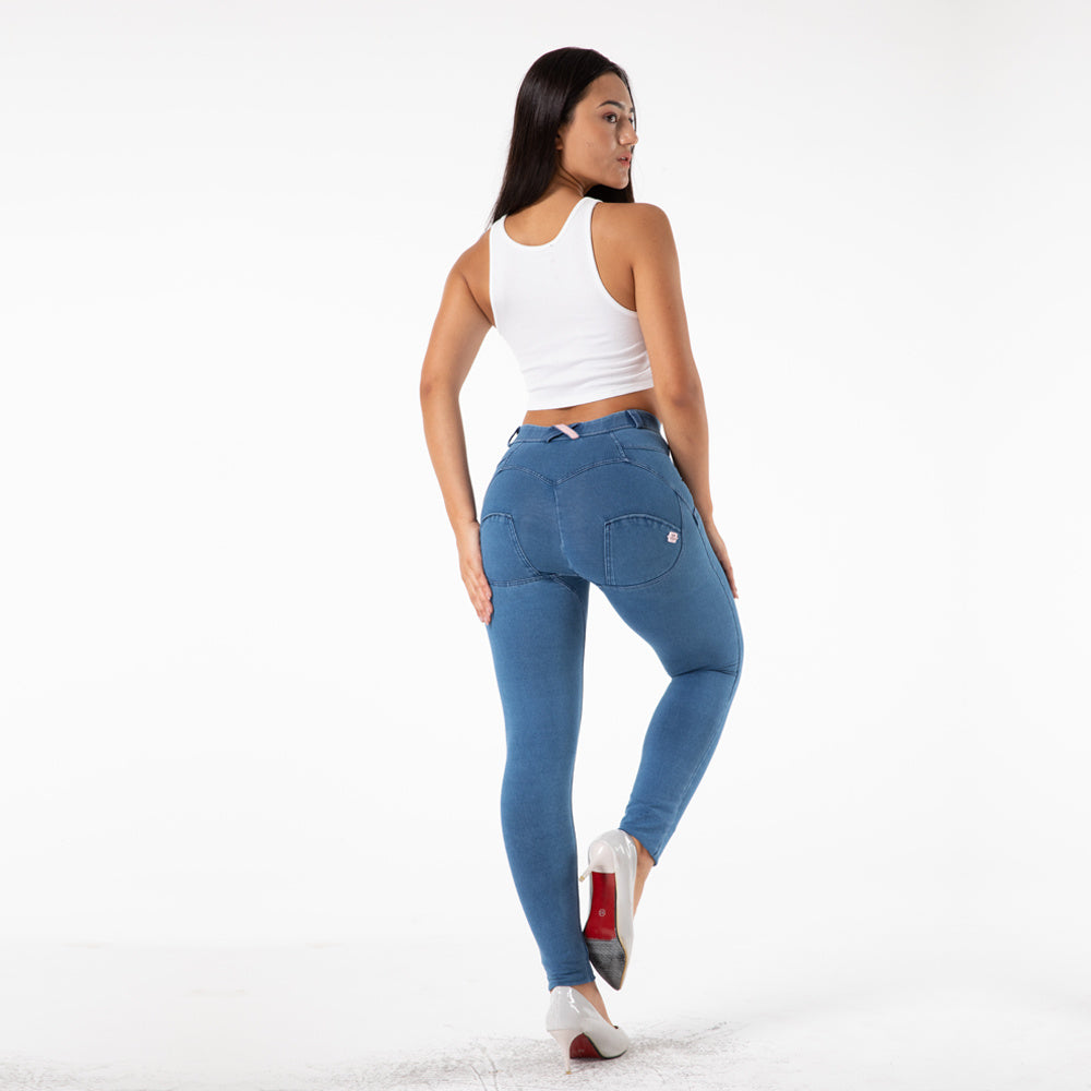 a woman in blue jeans and white tank top