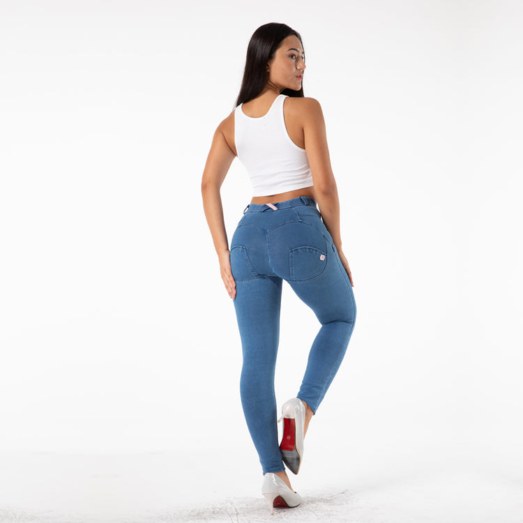 a woman in blue jeans and white tank top