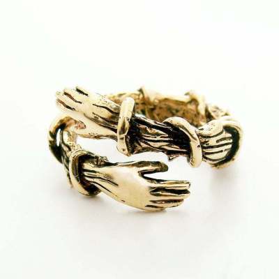 a gold ring with two hands