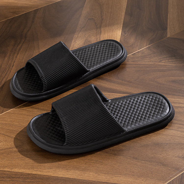 a pair of black slippers on a wood floor