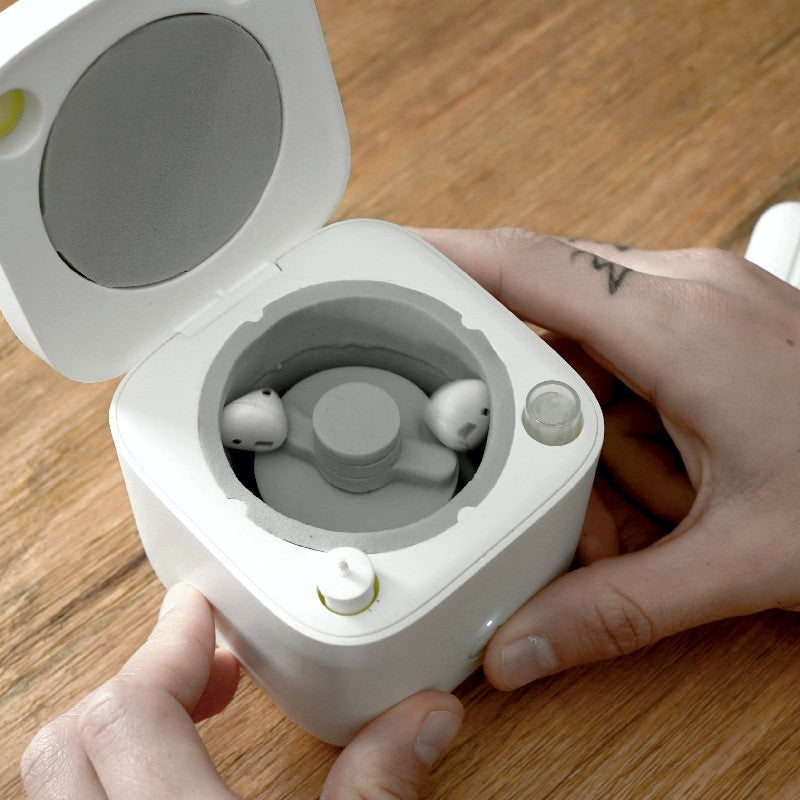 a person holding a white box with a round lid