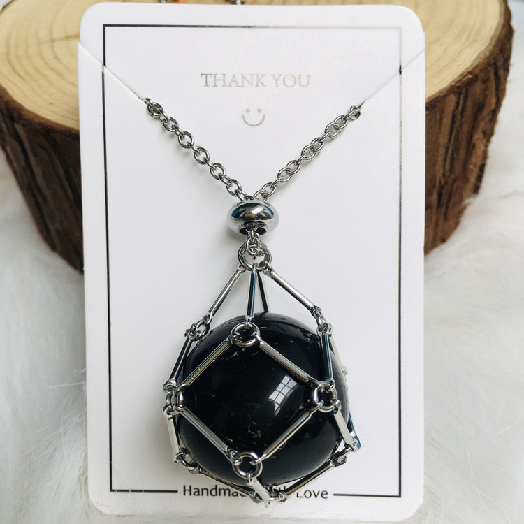 a necklace with a black stone in a wire mesh cage