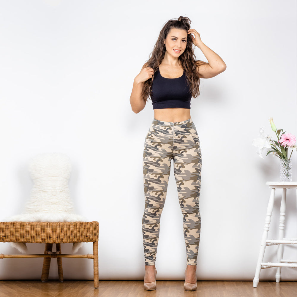 a woman in a black tank top and camouflage pants