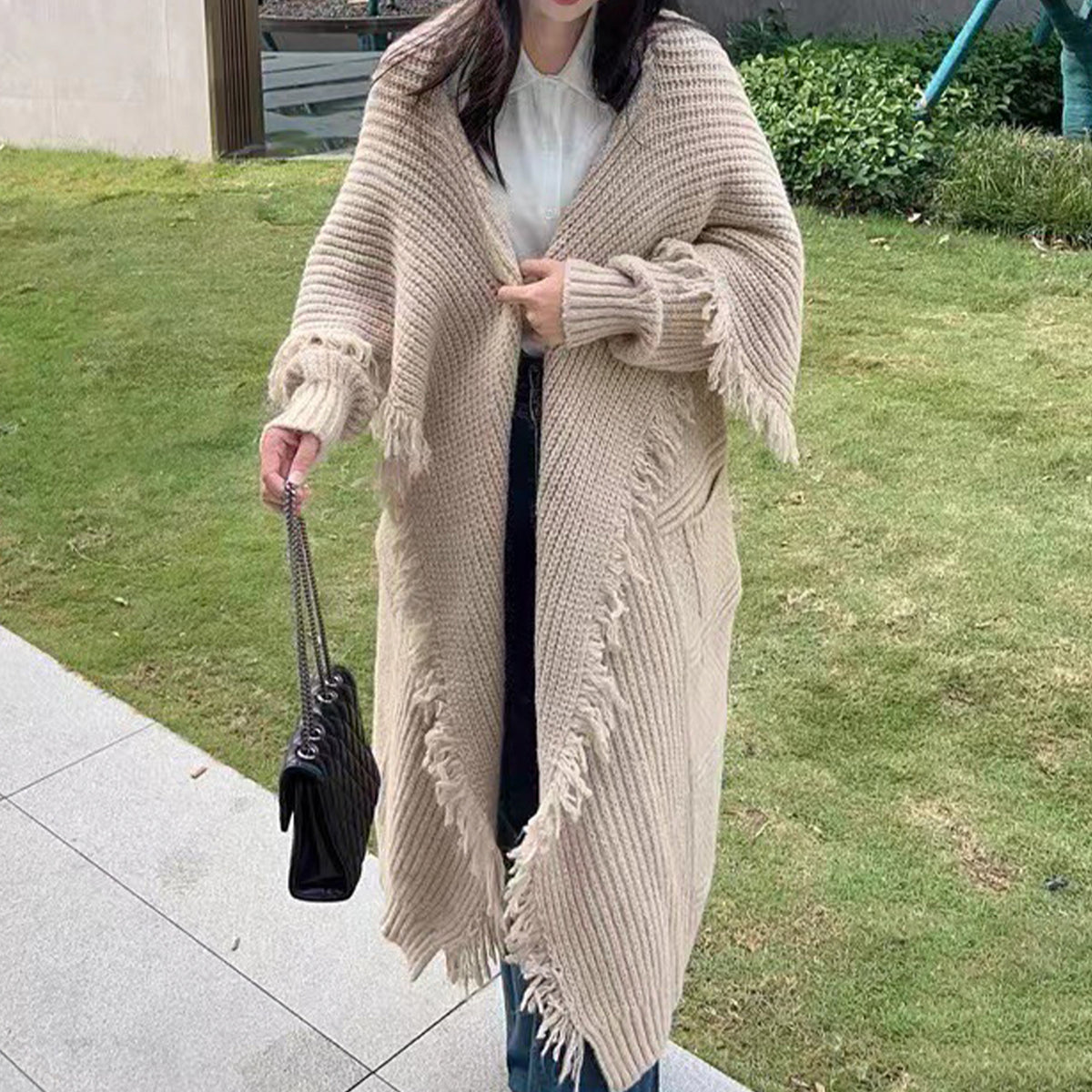 a woman wearing a long cardigan and jeans