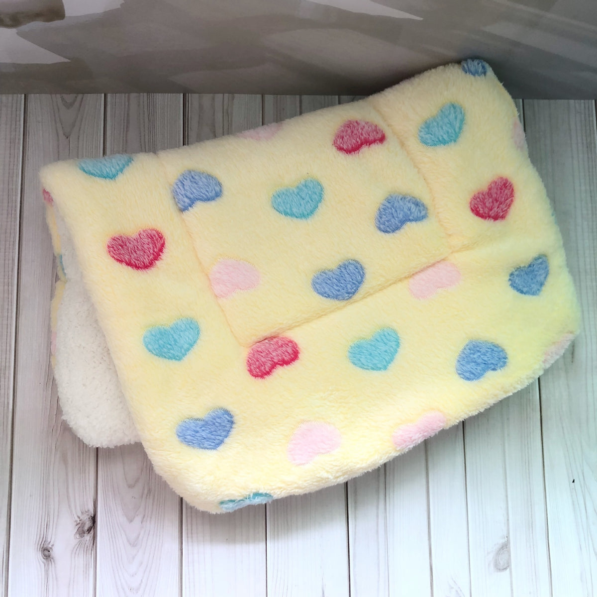 a yellow blanket with hearts on it