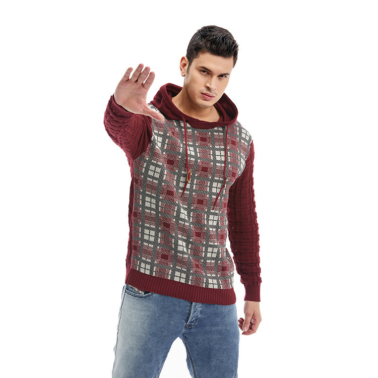 a man wearing a sweater and holding his hand up