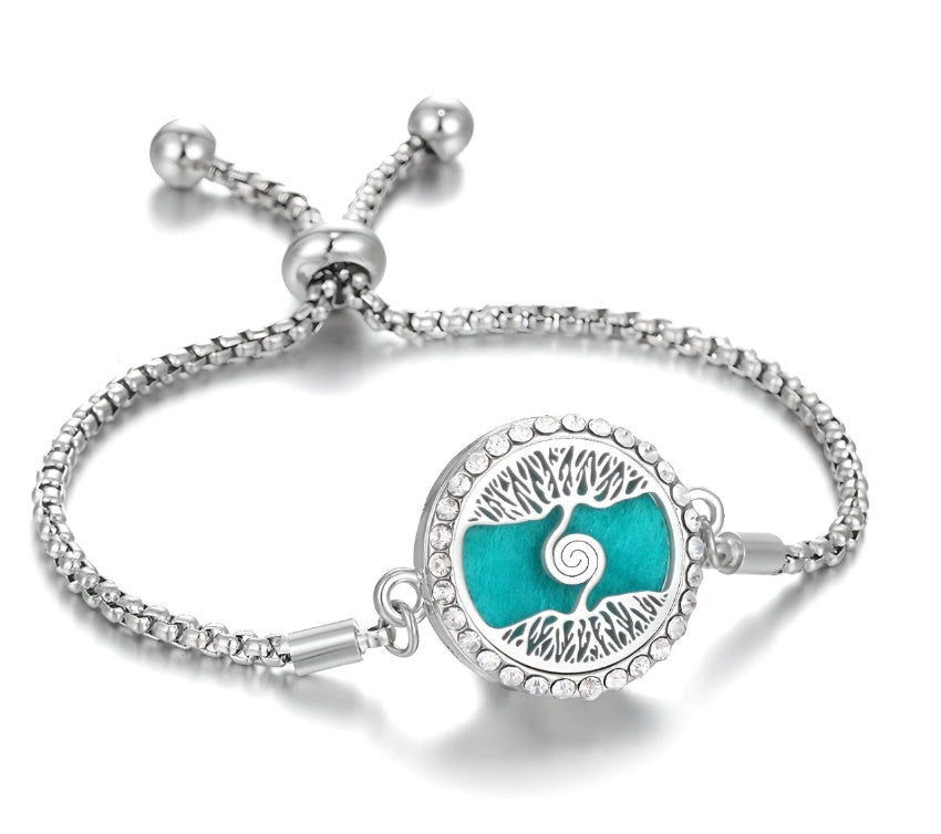 a silver bracelet with a blue circle and a swirl design