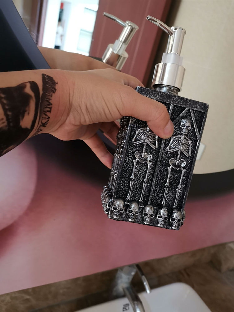 a hand holding a bottle with skulls on it
