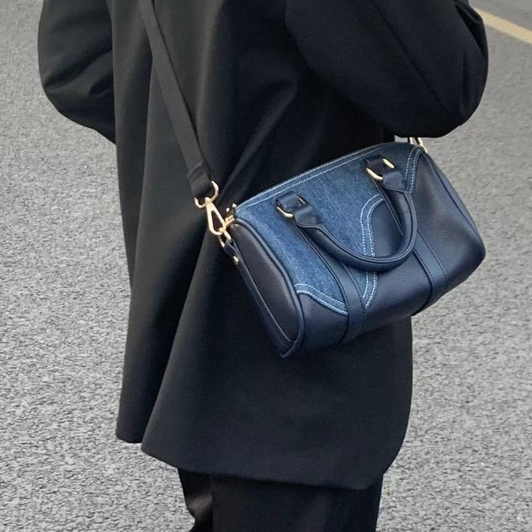 a person wearing a black coat and black pants holding a blue purse
