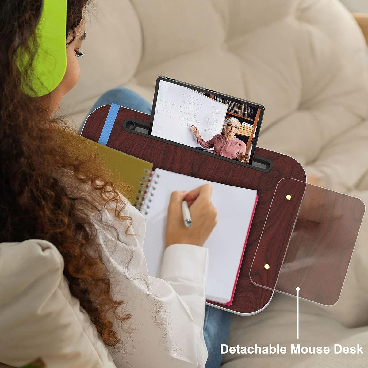 a woman sitting on a couch writing on a notebook