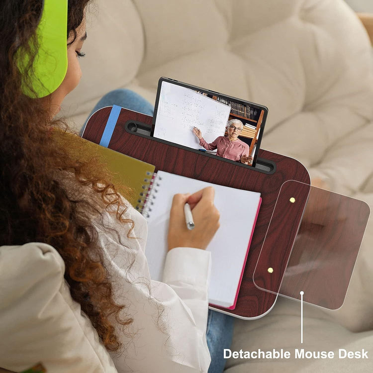 a woman sitting on a couch writing on a notebook
