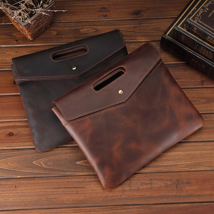 a pair of leather handbags on a wood surface