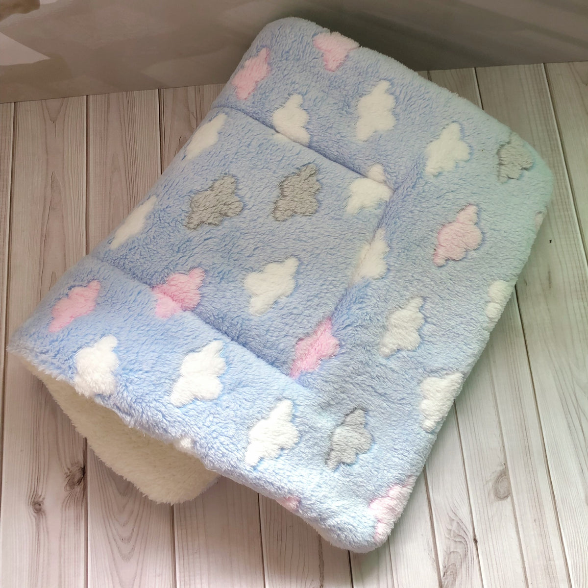 a blue and white blanket with clouds on it