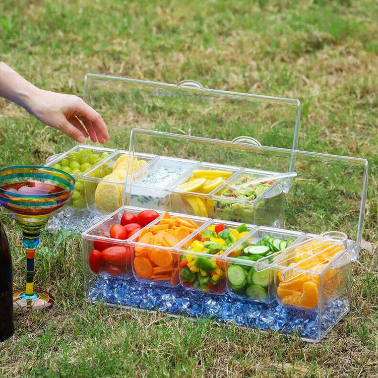 a plastic containers with different vegetables and fruits on the grass