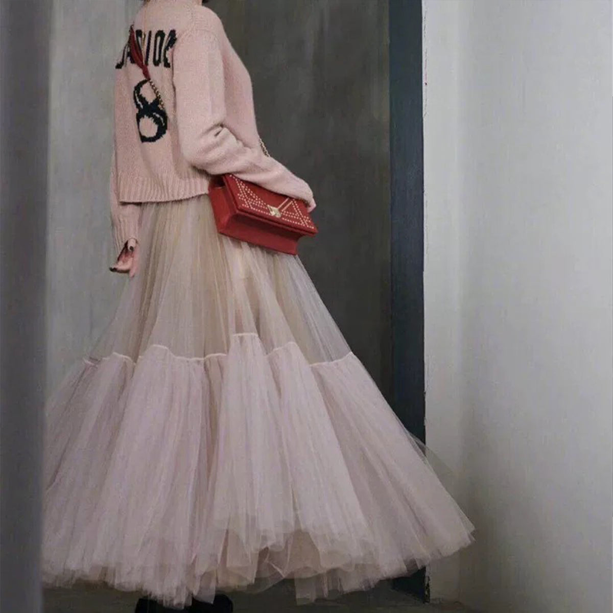 a woman in a pink sweater and tulle skirt