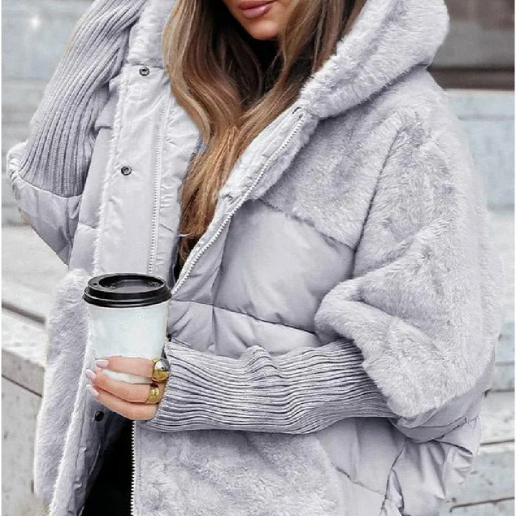 a woman wearing a hat and a coat holding a coffee cup