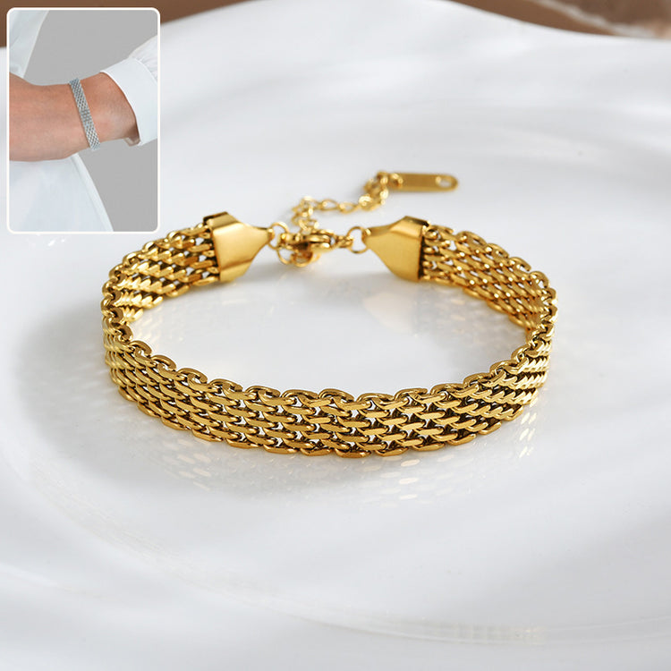 a gold bracelet on a white plate