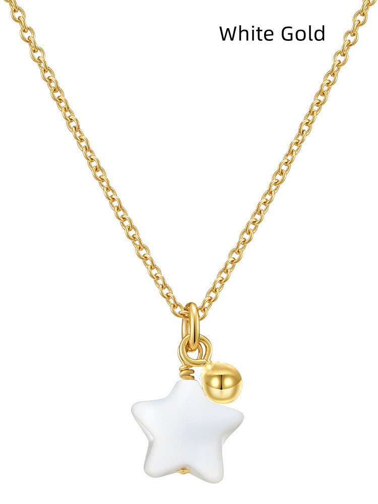 a gold chain with a white star pendant