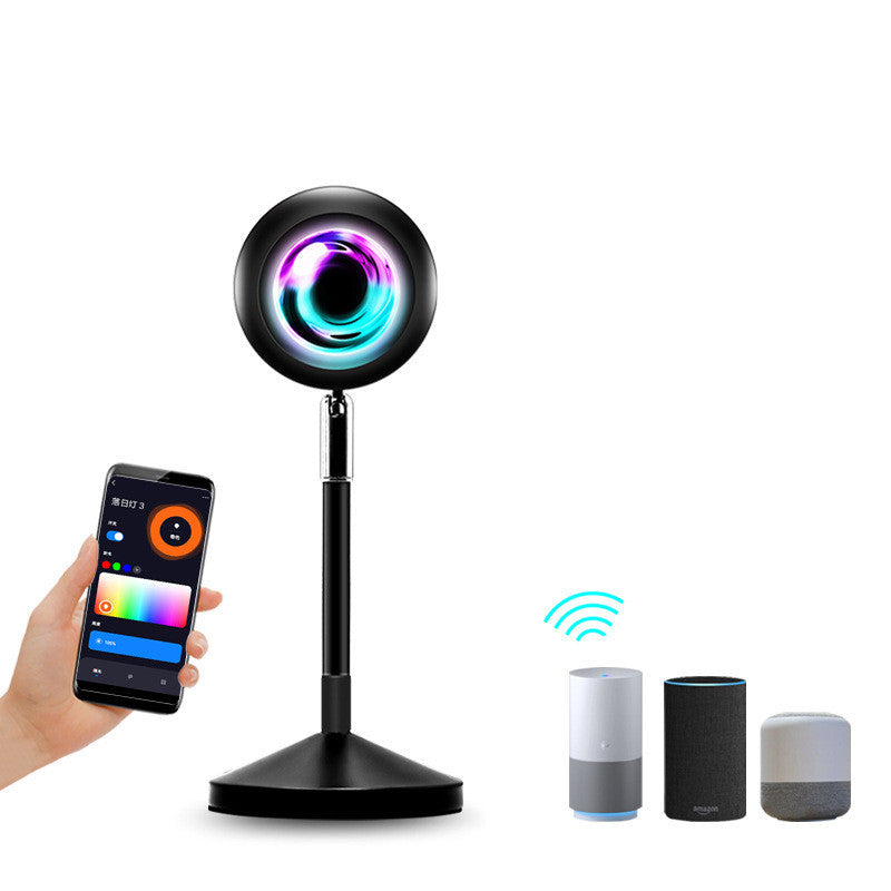 a hand holding a phone next to a round black object