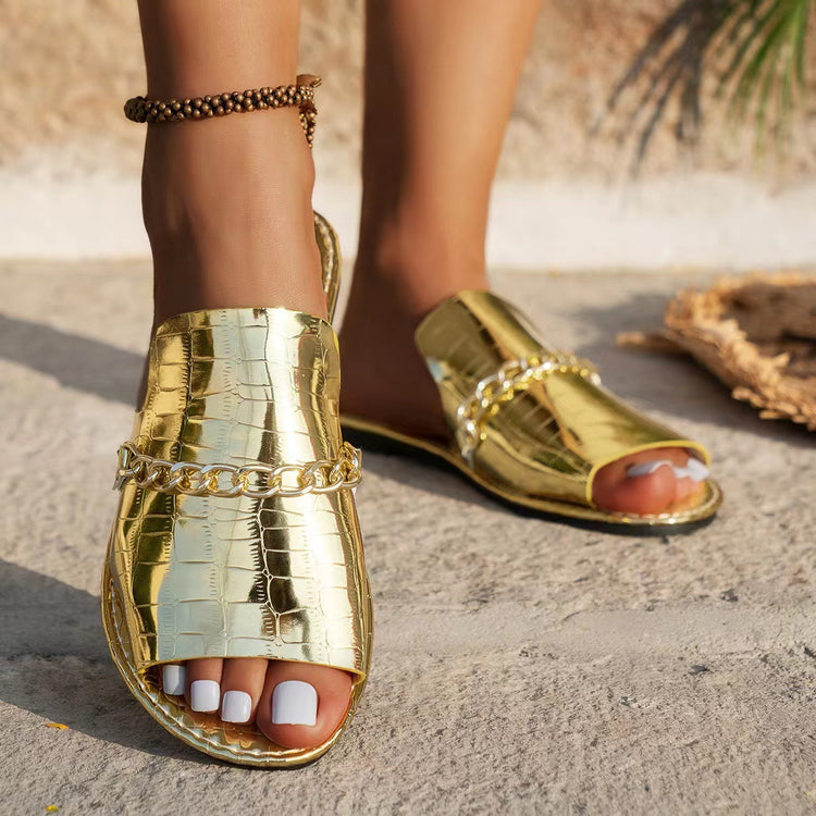 a person's feet wearing gold sandals