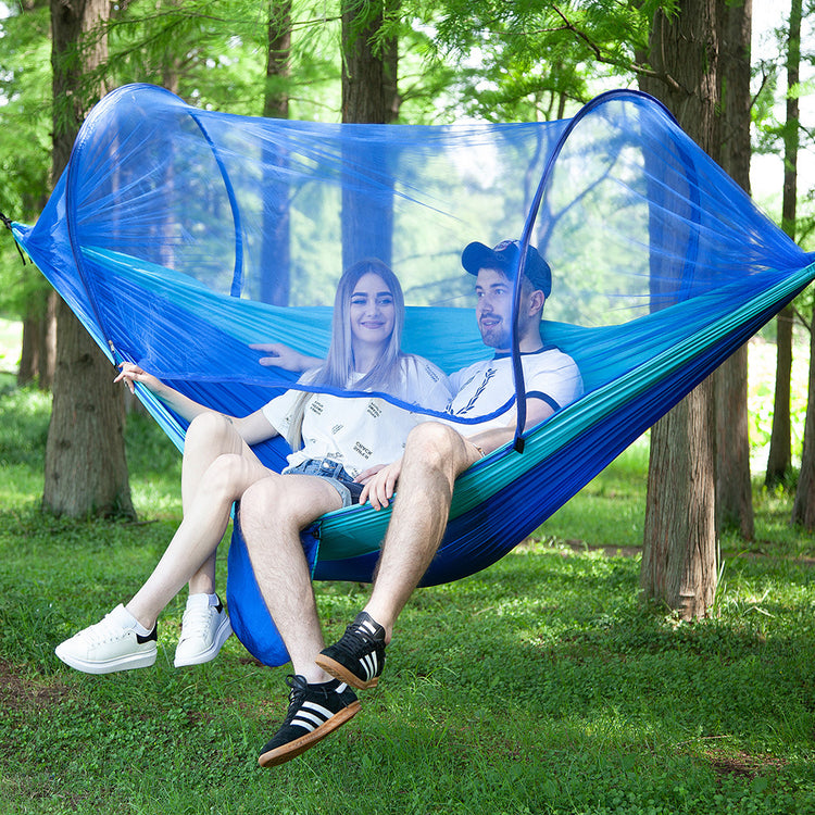 a man and woman sitting in a hammock